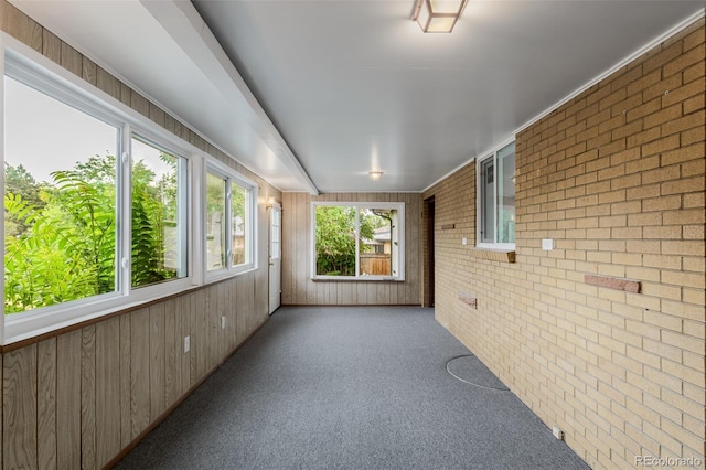 6994 Teller Ct, Arvada, CO 80003 - unfurnished sunroom with brick wall, carpet, and wood walls