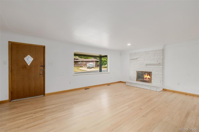 6994 Teller Ct, Arvada, CO 80003 - unfurnished living room with light wood finished floors and a stone fireplace