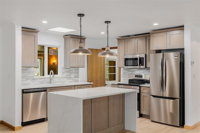 6994 Teller Ct, Arvada, CO 80003 - kitchen with stainless steel appliances, decorative backsplash, light countertops, light wood-type flooring, and a kitchen island