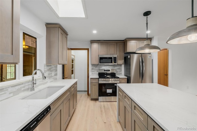 6994 Teller Ct, Arvada, CO 80003 - kitchen featuring stainless steel appliances, backsplash, light wood finished floors, light stone counters, and hanging light fixtures