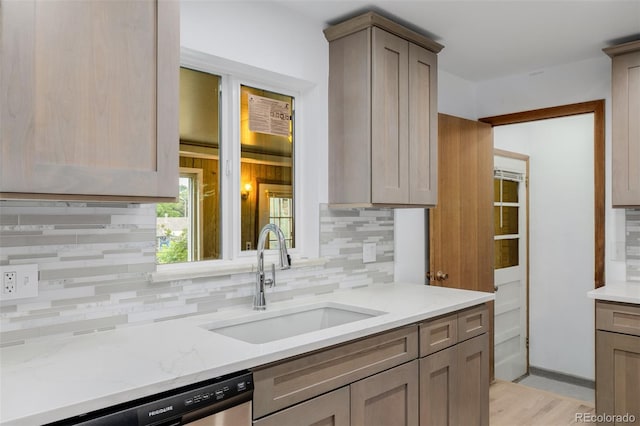 6994 Teller Ct, Arvada, CO 80003 - kitchen with tasteful backsplash, stainless steel dishwasher, light stone countertops, and light wood-style flooring