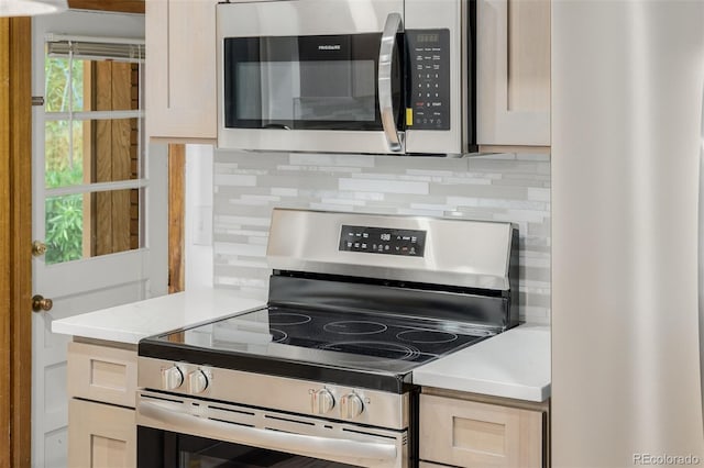 6994 Teller Ct, Arvada, CO 80003 - kitchen featuring appliances with stainless steel finishes, tasteful backsplash, and light countertops