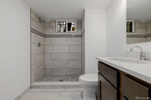 6994 Teller Ct, Arvada, CO 80003 - bathroom with vanity, a tile shower, and marble look tiles