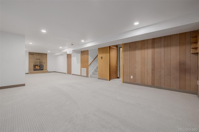 6994 Teller Ct, Arvada, CO 80003 - finished basement with light carpet, wooden walls, recessed lighting, stairs, and a brick fireplace