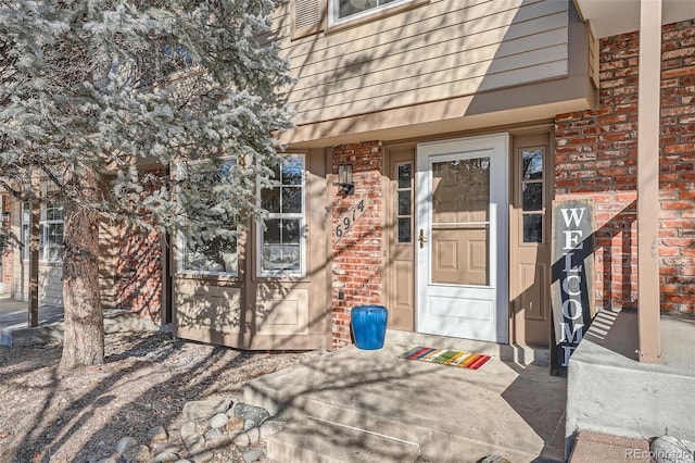 view of exterior entry featuring brick siding