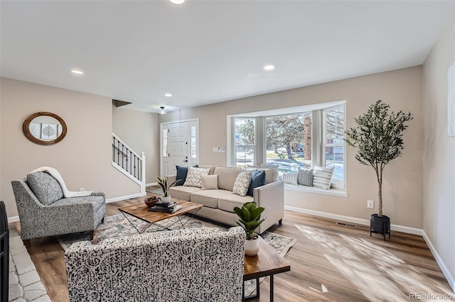 living room featuring recessed lighting, visible vents, stairway, wood finished floors, and baseboards