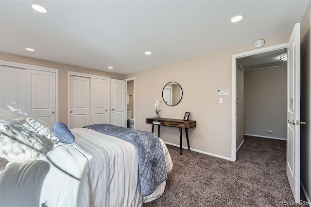 bedroom with dark colored carpet, recessed lighting, baseboards, and two closets