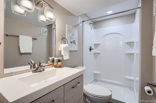 full bath with visible vents, vanity, toilet, and walk in shower