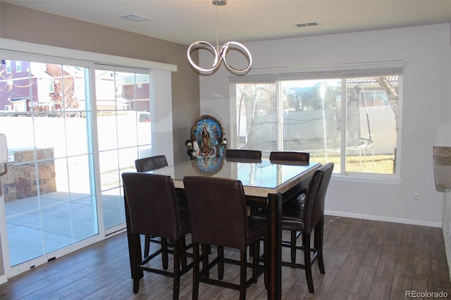 dining room featuring dark hardwood / wood-style floors and a chandelier