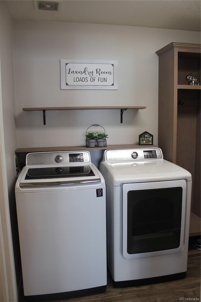 washroom featuring dark hardwood / wood-style flooring and washer and clothes dryer