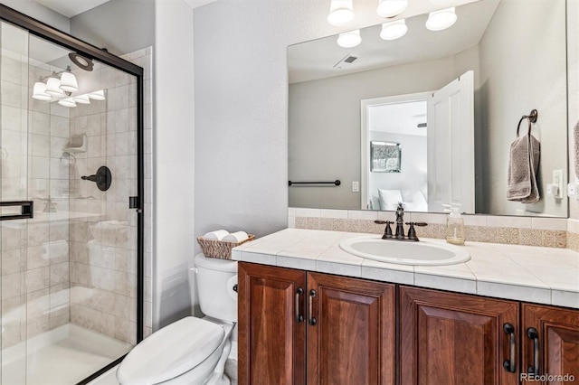 bathroom with vanity, a shower with shower door, and toilet