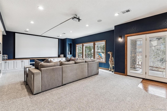 carpeted home theater with a textured ceiling