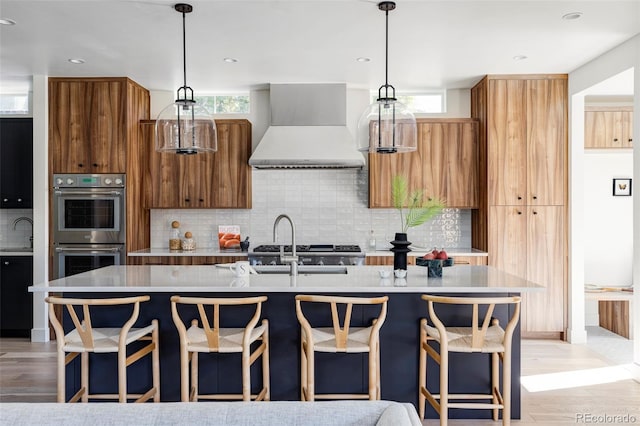 kitchen with custom range hood, plenty of natural light, and an island with sink