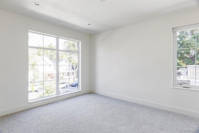 unfurnished room with carpet flooring and a healthy amount of sunlight