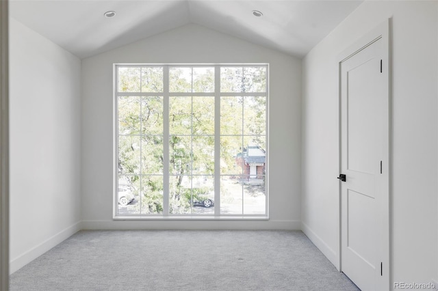 carpeted empty room featuring lofted ceiling and a healthy amount of sunlight