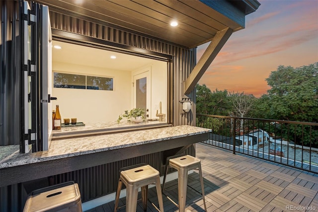 patio terrace at dusk featuring a balcony