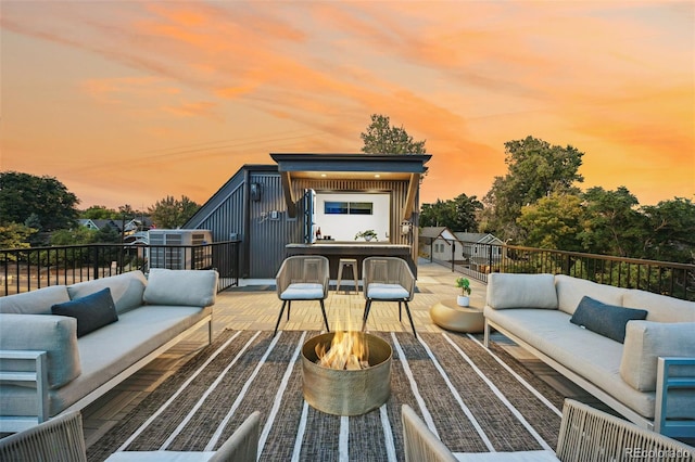 deck at dusk featuring an outdoor hangout area