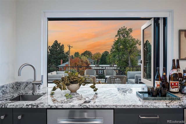 kitchen featuring sink and light stone counters