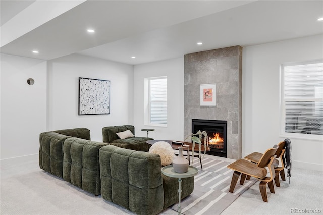 carpeted living room featuring a tiled fireplace