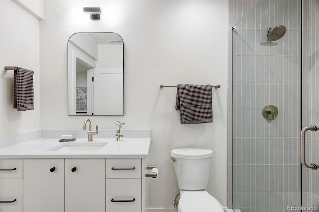 bathroom with vanity, toilet, and a tile shower