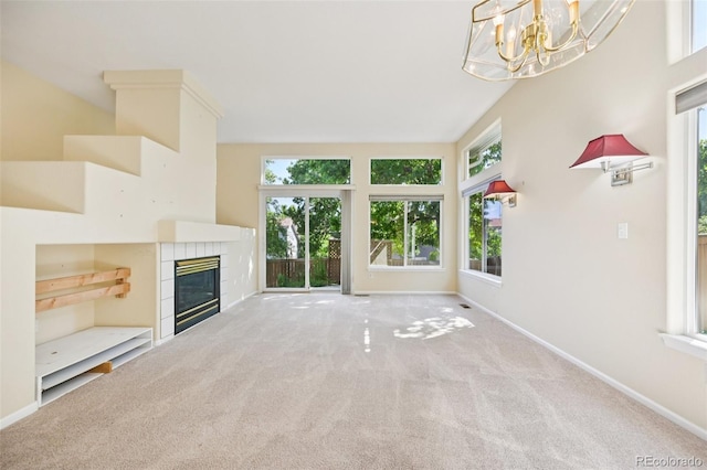 10231 Spotted Owl Ave, Highlands Ranch, CO 80129 - unfurnished living room featuring carpet, a chandelier, and a tiled fireplace