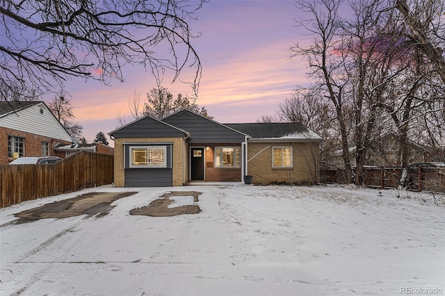 bungalow-style house with brick siding and fence