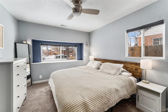 bedroom with baseboards, visible vents, a textured wall, a textured ceiling, and carpet flooring