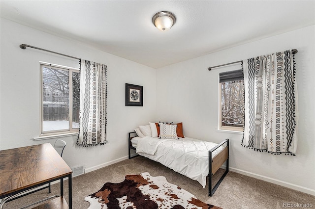 carpeted bedroom featuring visible vents and baseboards