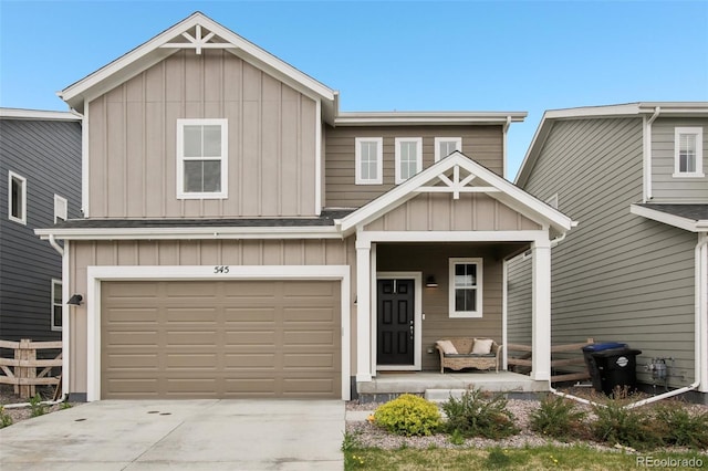 craftsman-style house featuring a garage, board and batten siding, fence, and driveway