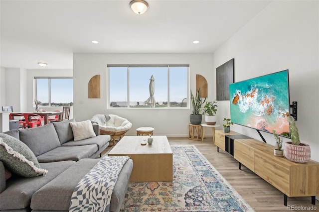 living area with light wood-type flooring, recessed lighting, and baseboards