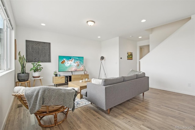 living room featuring light wood-style floors, baseboards, and recessed lighting