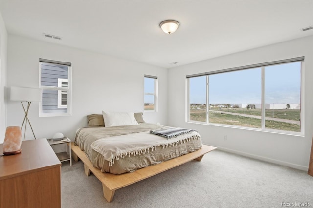 bedroom featuring baseboards, visible vents, and light carpet