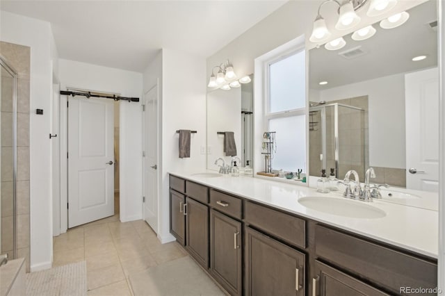 bathroom featuring double vanity, a sink, tile patterned flooring, and a stall shower