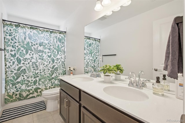 bathroom featuring double vanity, toilet, a sink, and tile patterned flooring