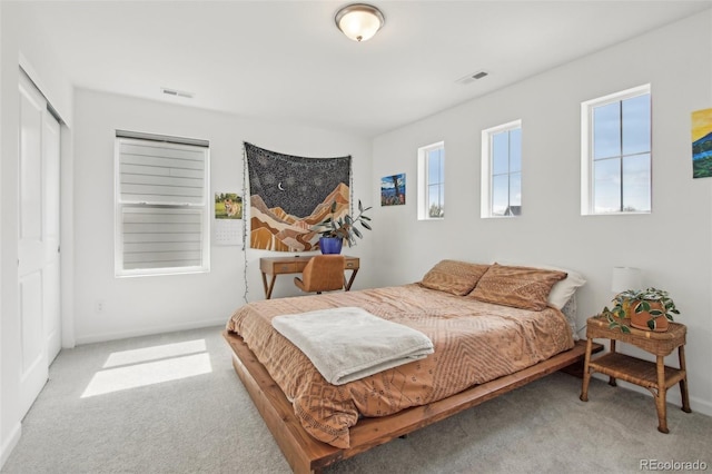 bedroom with baseboards, visible vents, and carpet