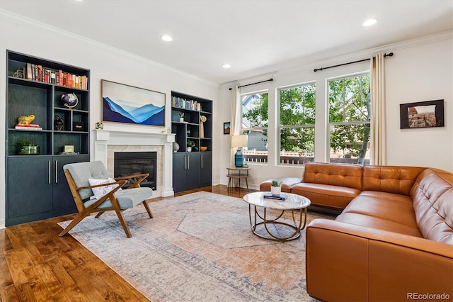 8695 E 49th Pl, Denver, CO 80238 - living room with wood finished floors, a glass covered fireplace, ornamental molding, recessed lighting, and built in shelves