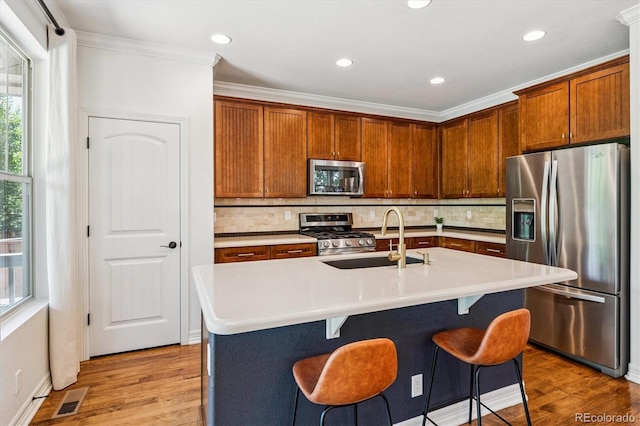 8695 E 49th Pl, Denver, CO 80238 - kitchen featuring stainless steel appliances, ornamental molding, decorative backsplash, light countertops, and light wood finished floors