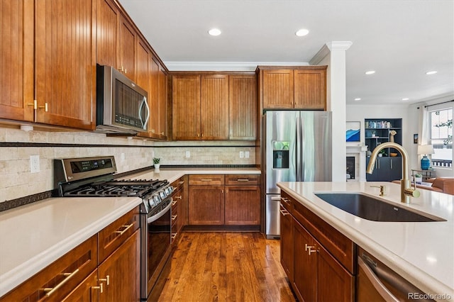 8695 E 49th Pl, Denver, CO 80238 - kitchen with appliances with stainless steel finishes, dark wood-style flooring, recessed lighting, decorative backsplash, and light countertops