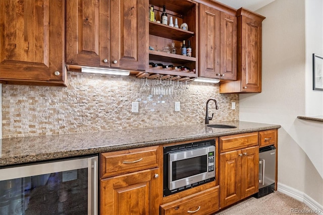 8695 E 49th Pl, Denver, CO 80238 - kitchen featuring stainless steel microwave, beverage cooler, brown cabinetry, and decorative backsplash