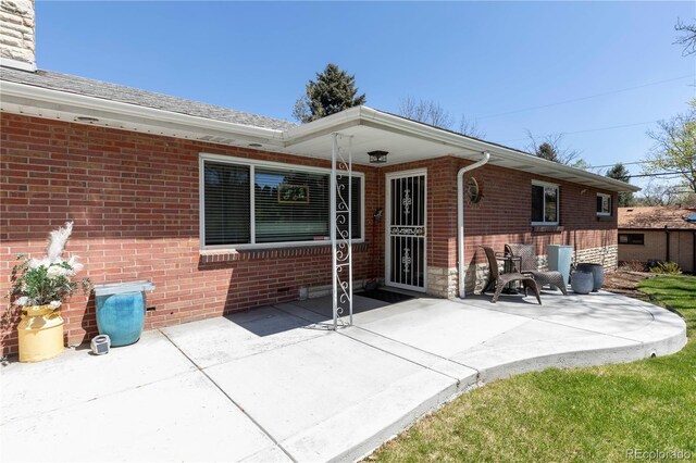 12375 W 19th Pl, Lakewood, CO 80215 - rear view of house featuring brick siding and a patio