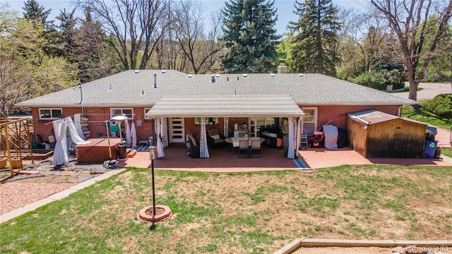 12375 W 19th Pl, Lakewood, CO 80215 - back of property with a hot tub, a patio, brick siding, and a yard
