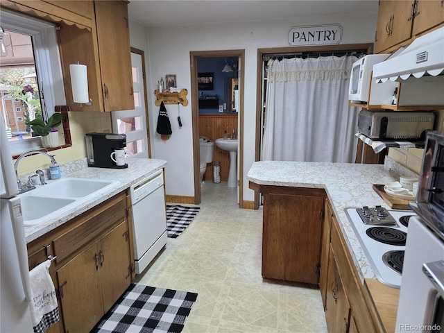 12375 W 19th Pl, Lakewood, CO 80215 - kitchen with white appliances, a sink, light countertops, light flooring, and brown cabinets