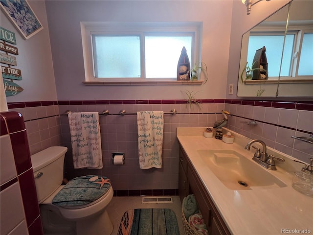 12375 W 19th Pl, Lakewood, CO 80215 - half bathroom featuring tile walls, a wainscoted wall, toilet, and vanity