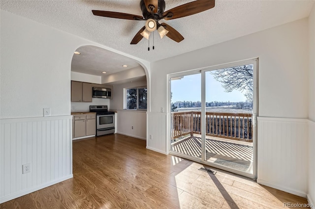 interior space featuring ceiling fan, a textured ceiling, and light wood-type flooring