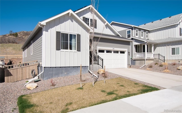 view of front of home with board and batten siding, fence, and concrete driveway