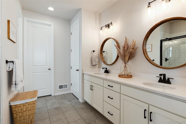 bathroom featuring double vanity, visible vents, a sink, and a stall shower