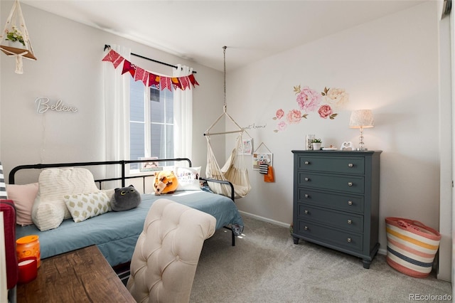 bedroom featuring light carpet and baseboards