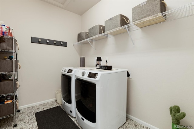 clothes washing area featuring laundry area, washing machine and clothes dryer, and baseboards