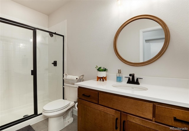 full bath featuring tile patterned floors, toilet, a stall shower, and vanity