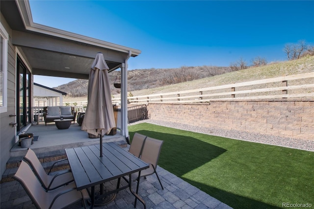 view of patio / terrace featuring a mountain view, a fenced backyard, outdoor lounge area, and outdoor dining space